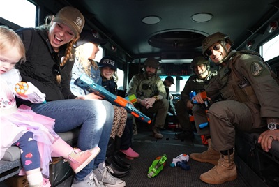 family in a swat car with police